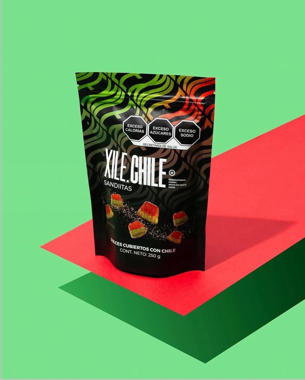 Bolsa XILE.CHILE Sandiitas de 250 gramos sobre fondo verde y rojo